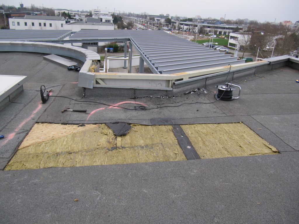 Complexe bitume en phase d'être déposé pour destruction et descente au sol (isolant apparent)